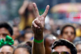 A man holds up a peace sign in a crowd while watching performers at the Brazilian Day 2017 festival in New York City